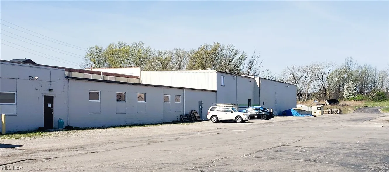 View of building exterior featuring uncovered parking