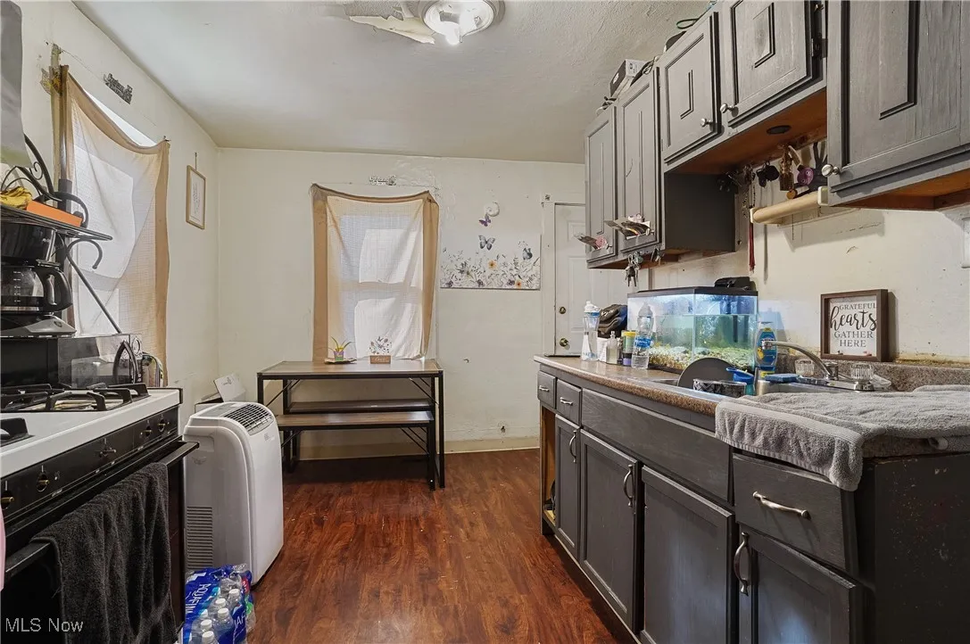 Kitchen featuring gas range oven, dark wood-style flooring, and light countertops