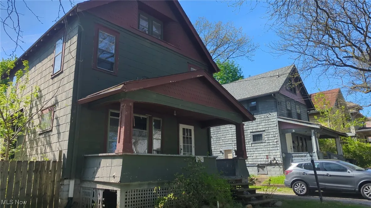 View of property exterior featuring fence and covered porch