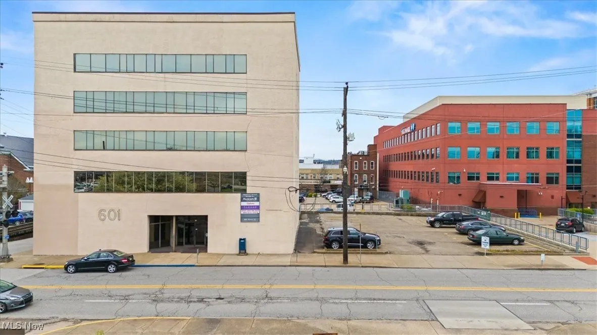 View of building exterior with uncovered parking