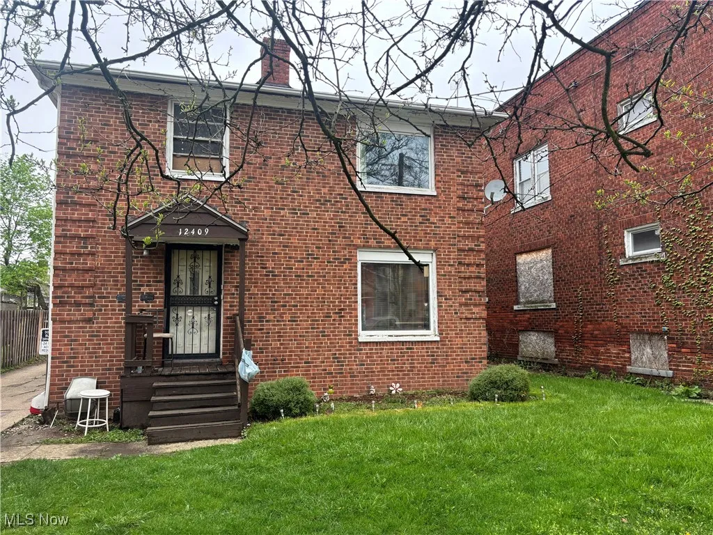 View of front of house with a front lawn and brick siding