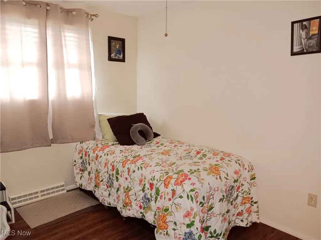 Bedroom featuring visible vents, baseboards, and dark wood-style floors