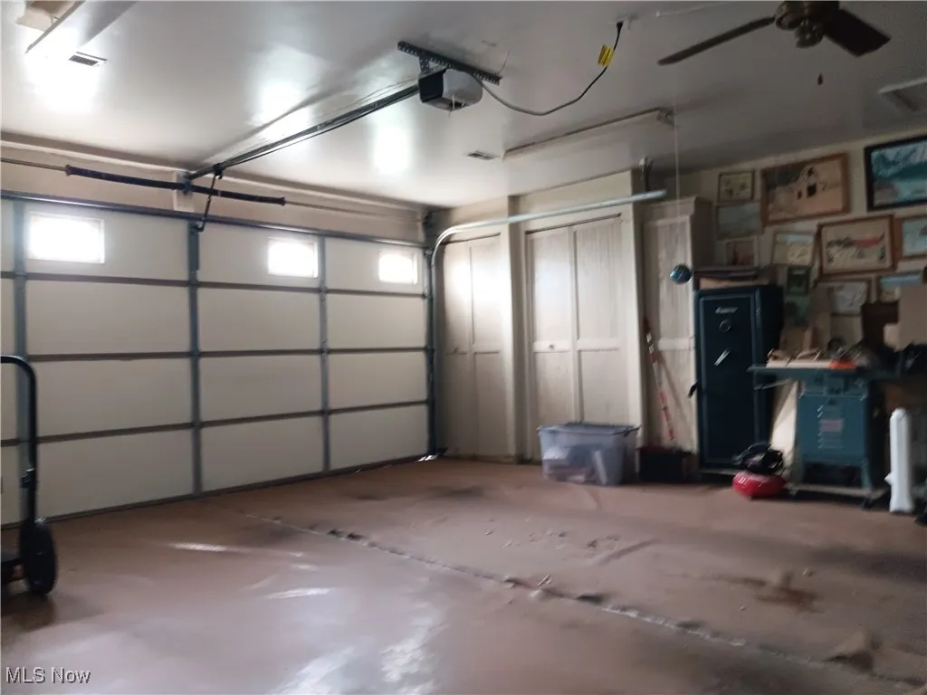 Garage with a ceiling fan and a garage door opener