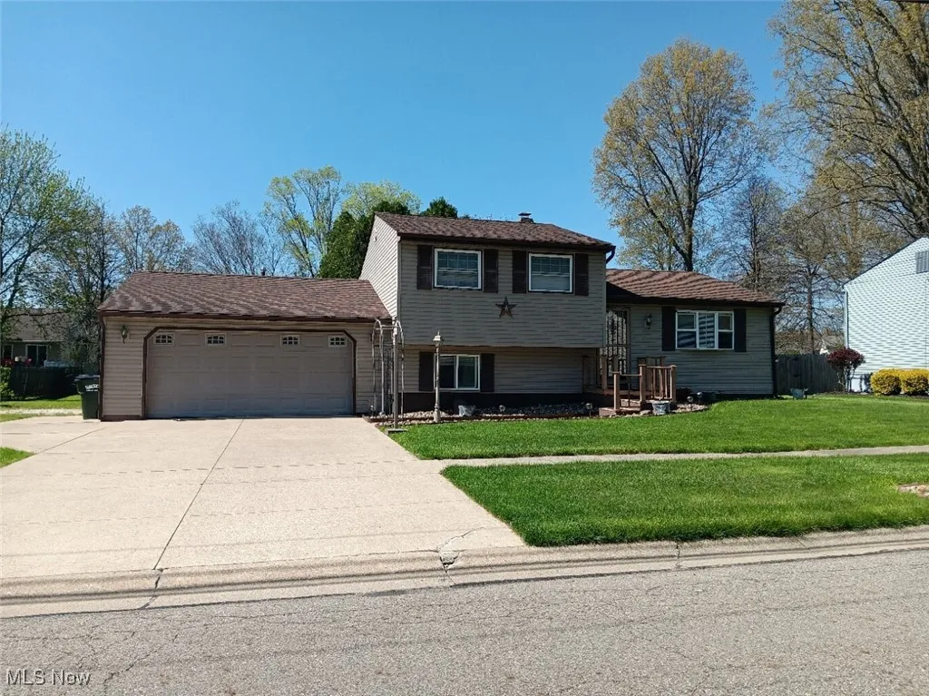 Tri-level home featuring a front yard, driveway, and an attached garage