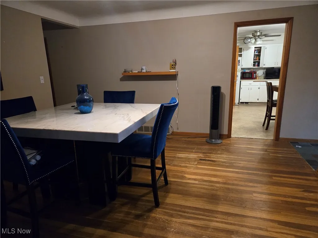 Dining area with baseboards, ceiling fan, and hardwood / wood-style floors