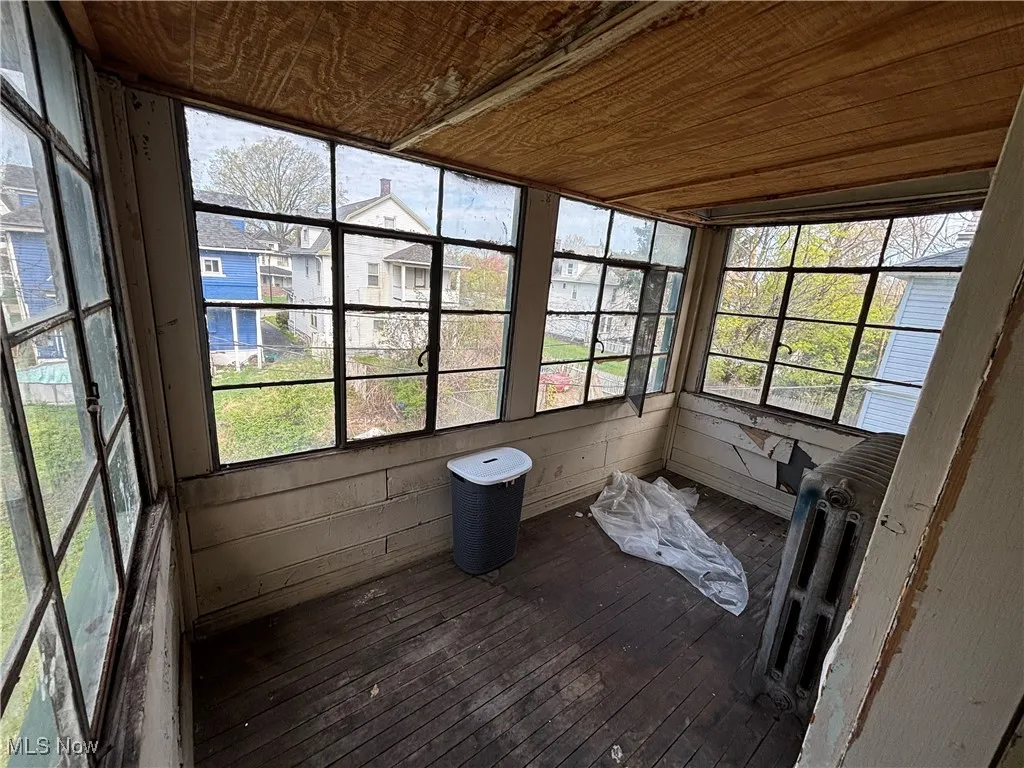 Unfurnished sunroom featuring wood-type flooring, wood ceiling, and wooden walls