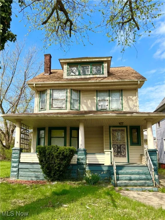 View of front of house featuring covered porch, a chimney, and roof with shingles