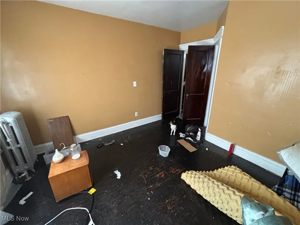 Bedroom with baseboards and radiator heating unit