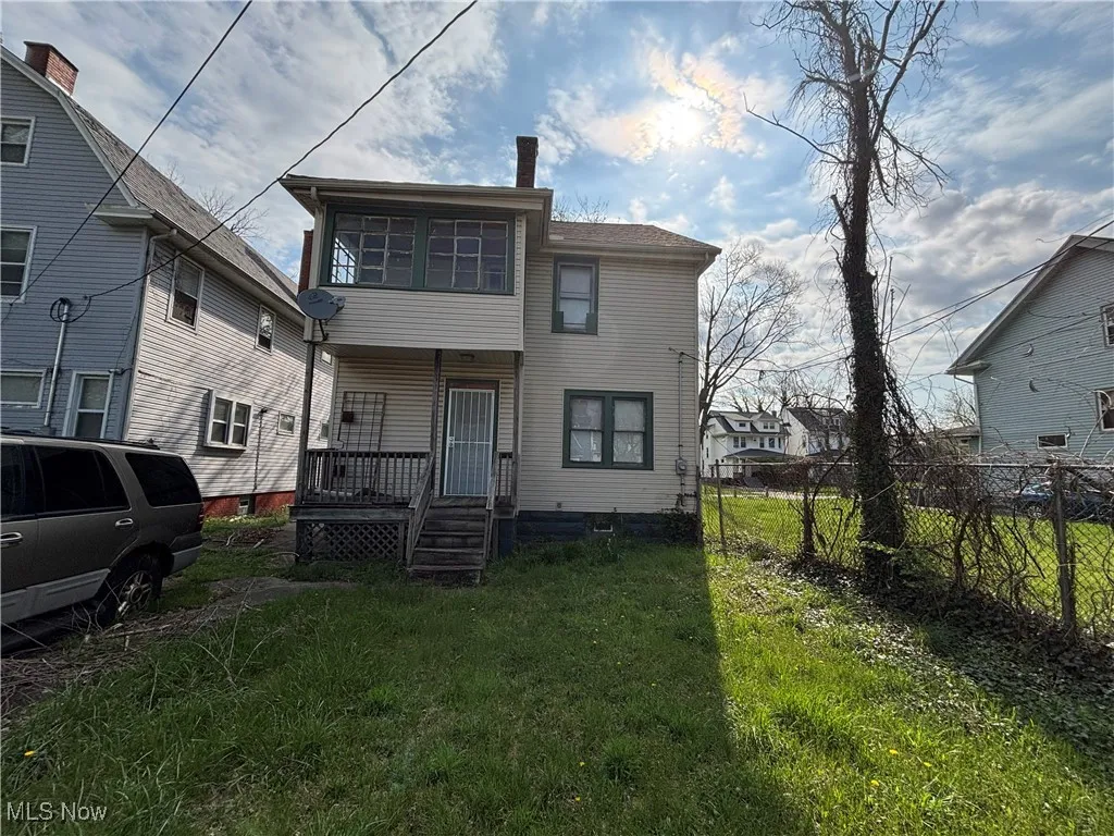 Rear view of property with fence, a yard, and a porch