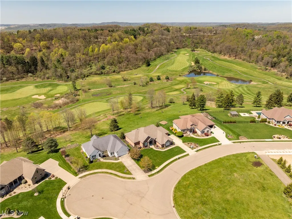 Drone / aerial view with a water view, a forest view, a residential view, and view of golf course