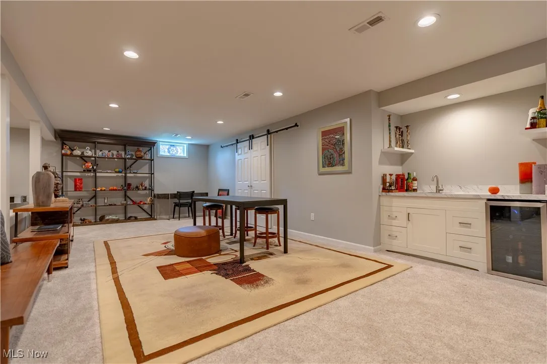 Playroom featuring a barn door, wine cooler, visible vents, wet bar, and light colored carpet