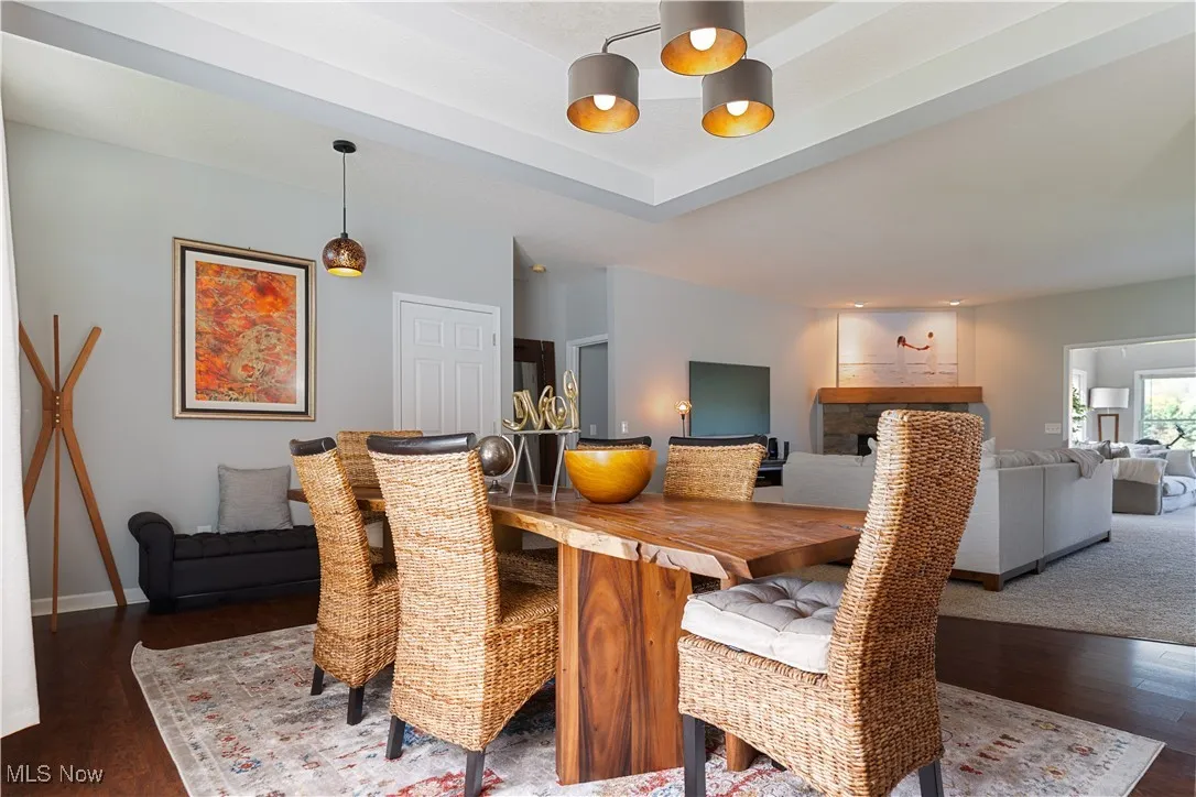 Dining room with baseboards, wood finished floors, an inviting chandelier, and a fireplace
