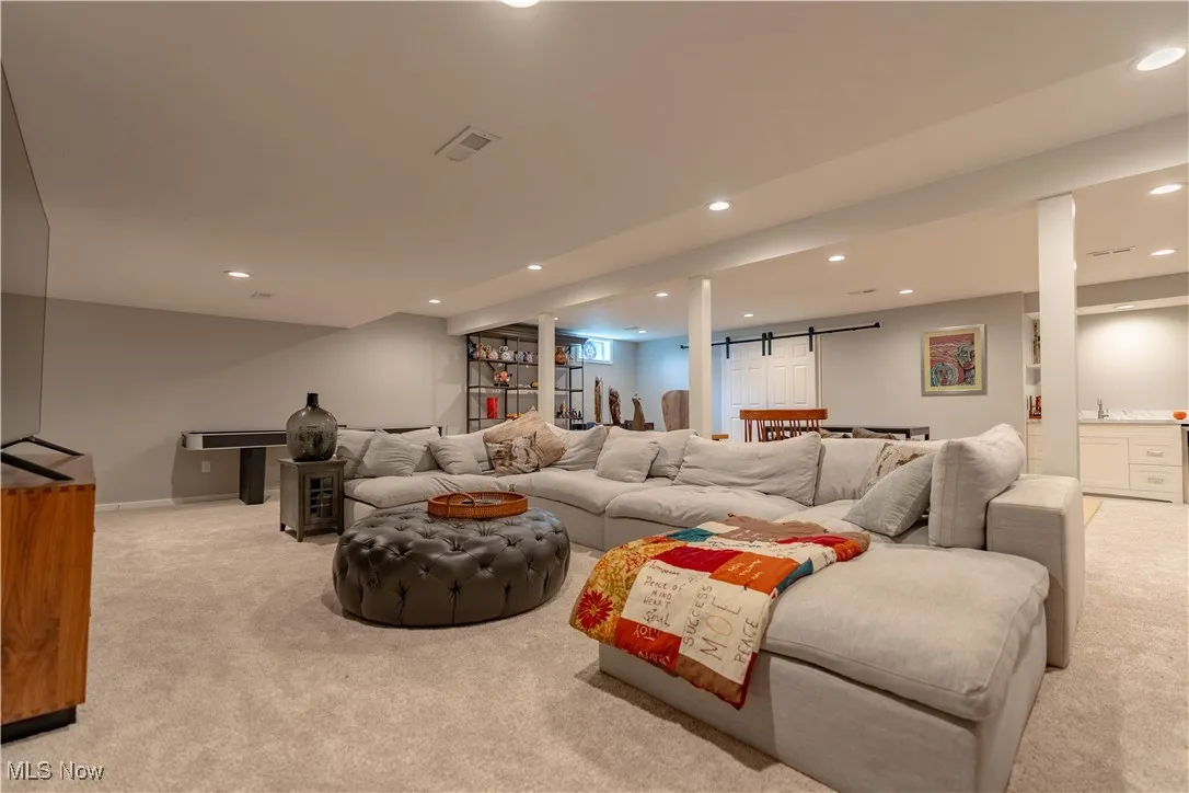 Living area with recessed lighting, baseboards, and light carpet