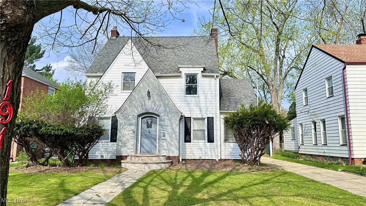 English style home featuring a front yard, a chimney, and roof with shingles