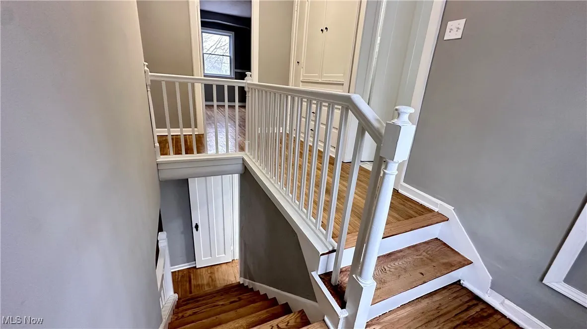 Stairway featuring baseboards and wood finished floors
