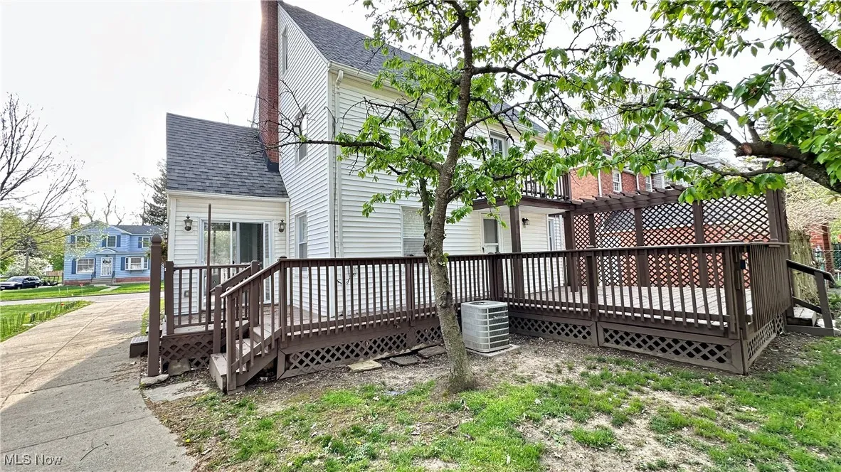 Back of house with roof with shingles, a wooden deck, a pergola, and cooling unit