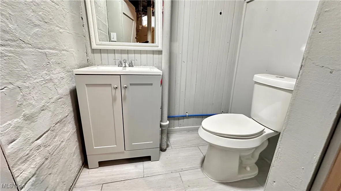 Bathroom with vanity, wood finished floors, and toilet