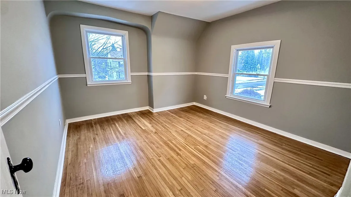 Spare room featuring baseboards and wood finished floors