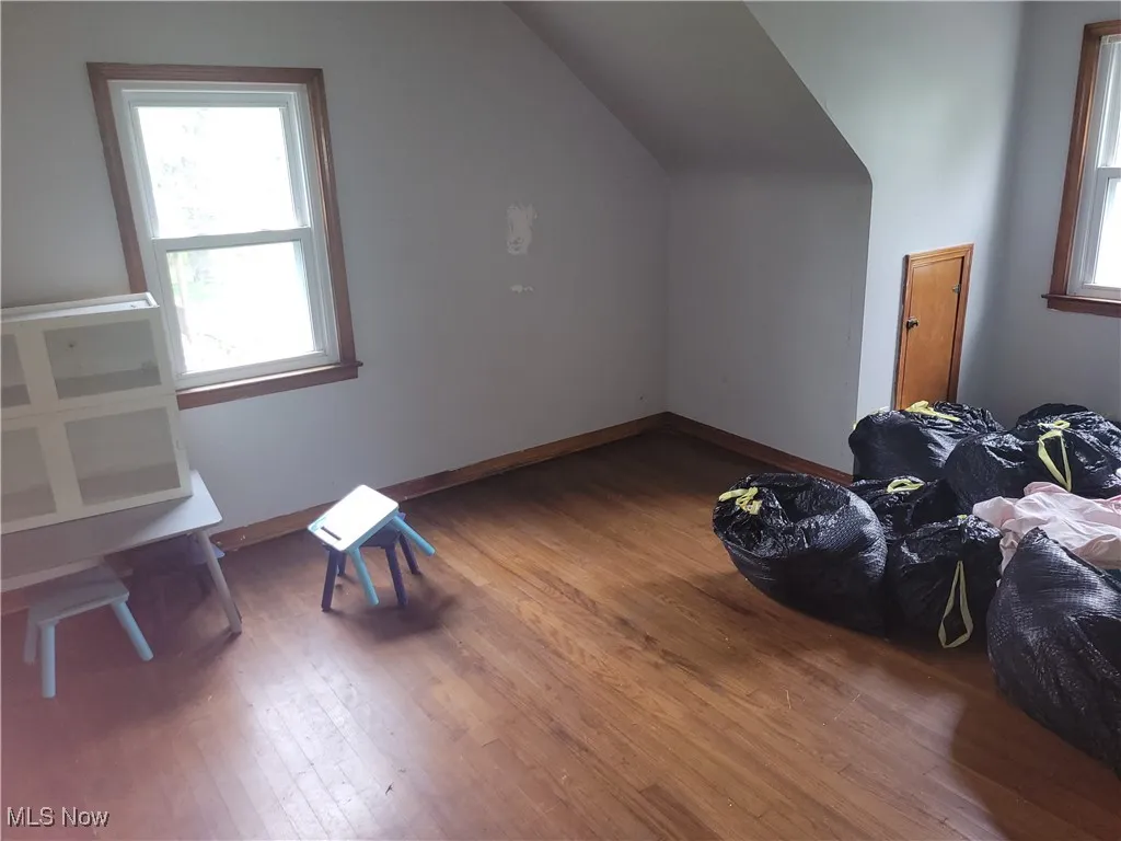 Bonus room featuring baseboards, wood finished floors, and lofted ceiling