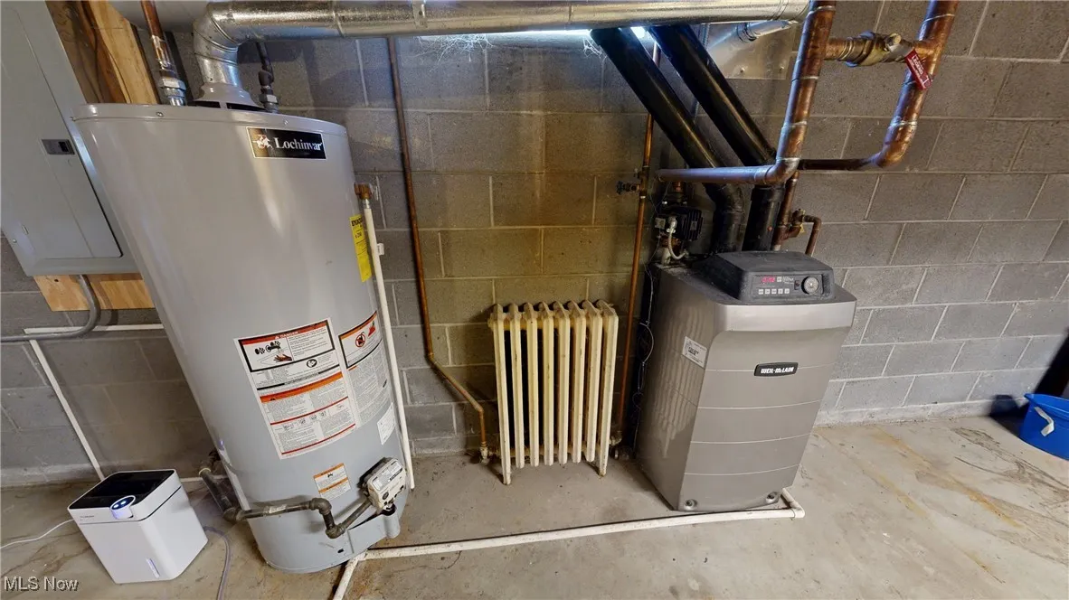 Utility room featuring boiler and water heater