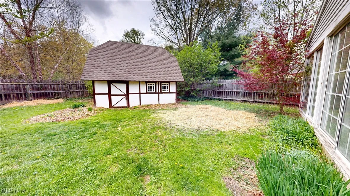 View of yard with a storage unit, a fenced backyard, and an outdoor structure