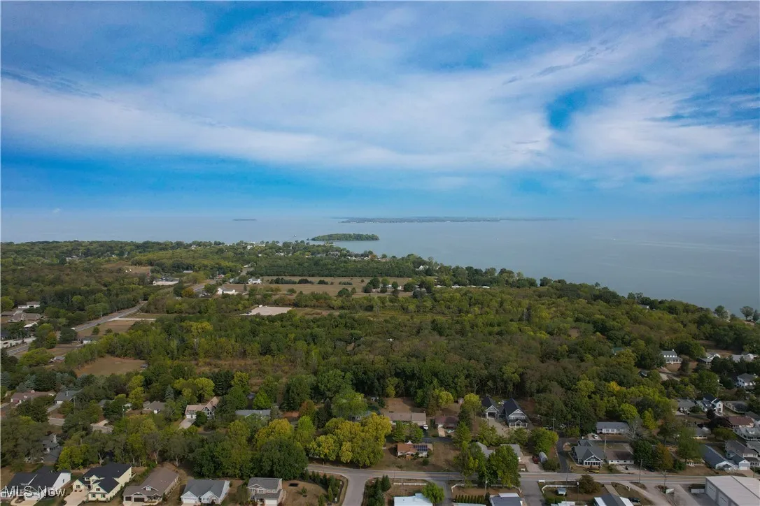 Aerial view with a water view, a view of trees, and a residential view