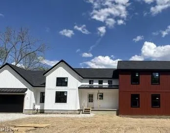 Modern inspired farmhouse with driveway and a garage