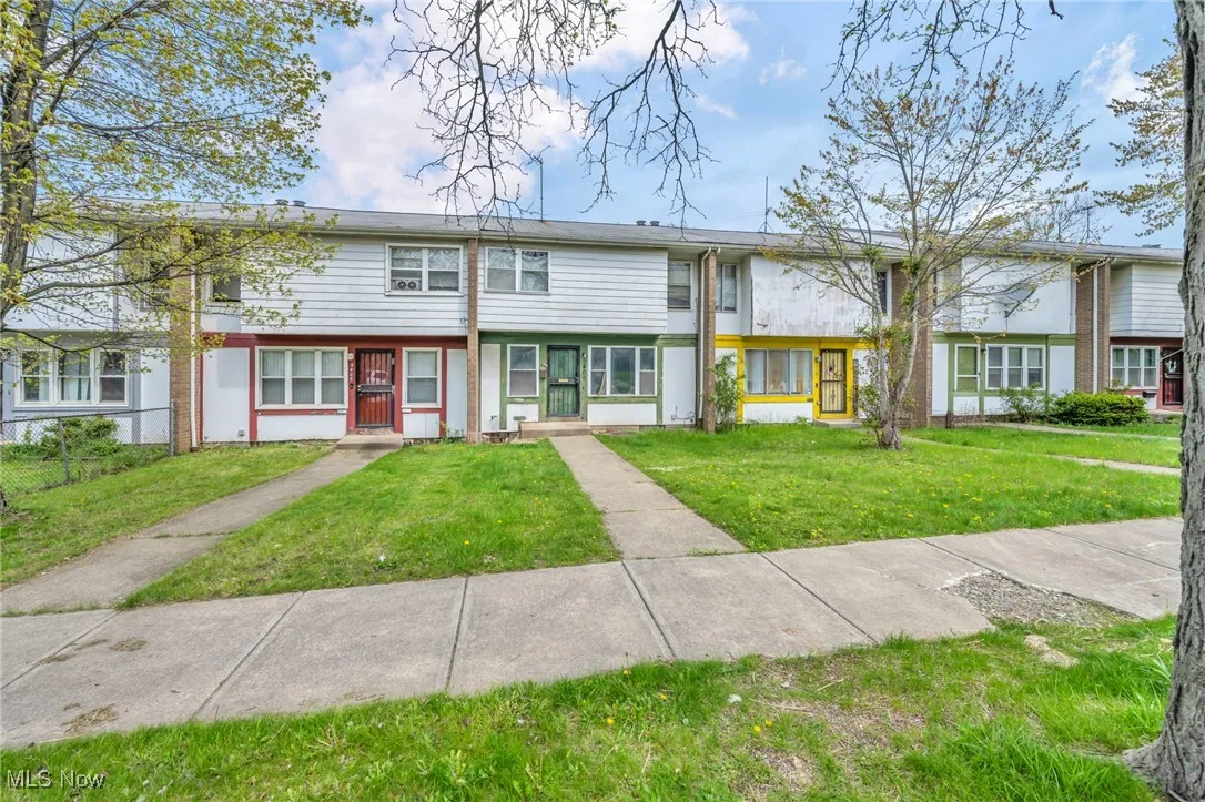 Townhome / multi-family property featuring fence and a front yard
