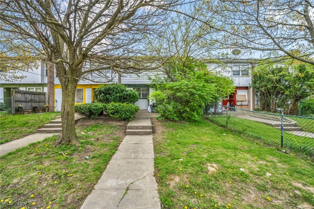View of front of home featuring fence and a front yard