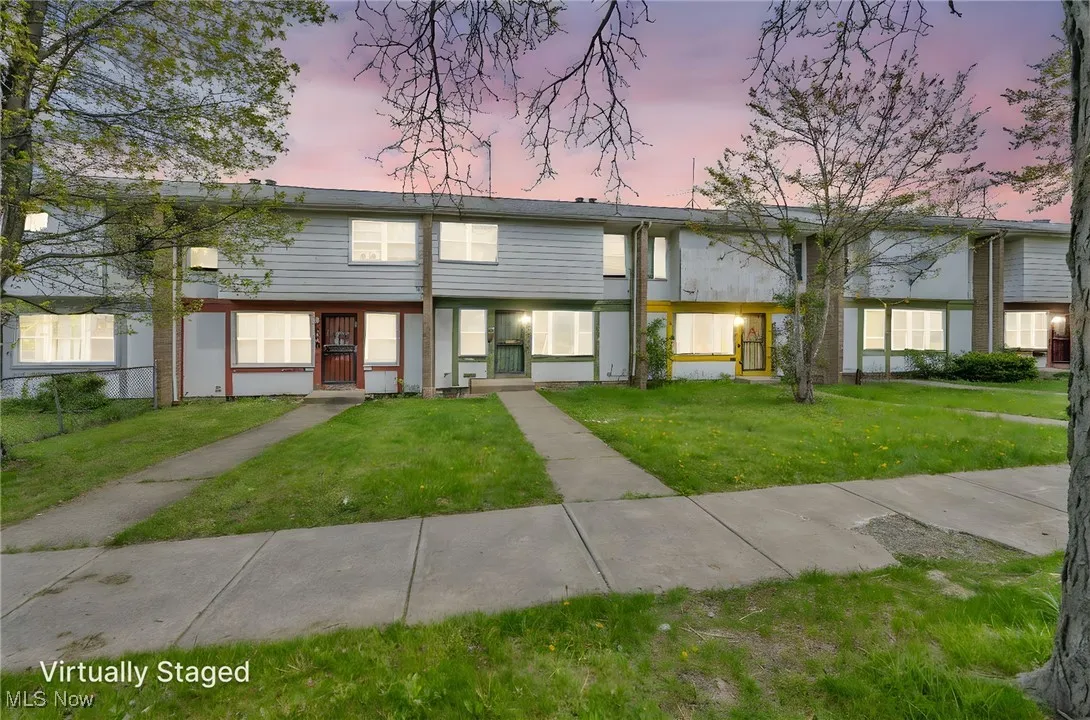 Multi unit property featuring fence and a front lawn