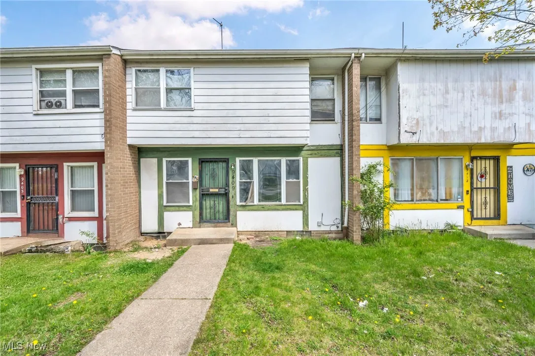 Townhome / multi-family property featuring a front yard