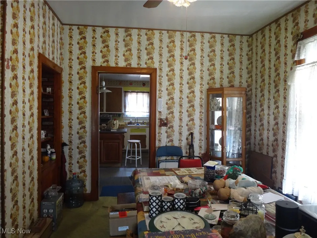 Dining room featuring a ceiling fan and wallpapered walls