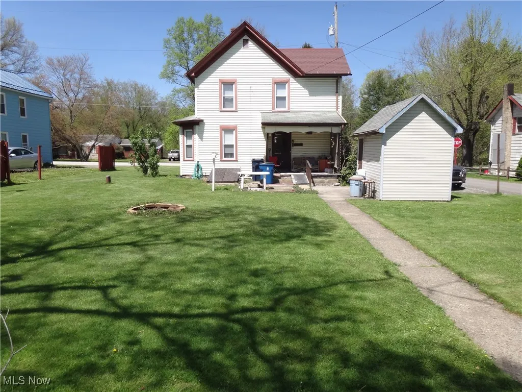 Back of property with a yard and a porch