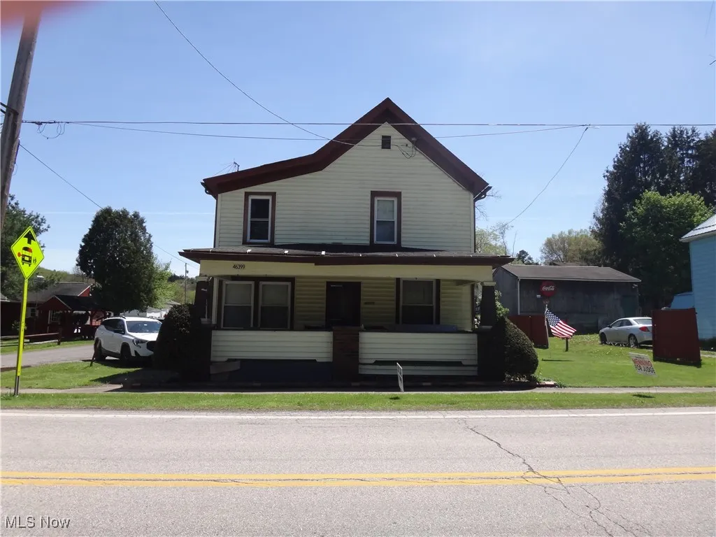 View of front of home featuring covered porch and a front lawn