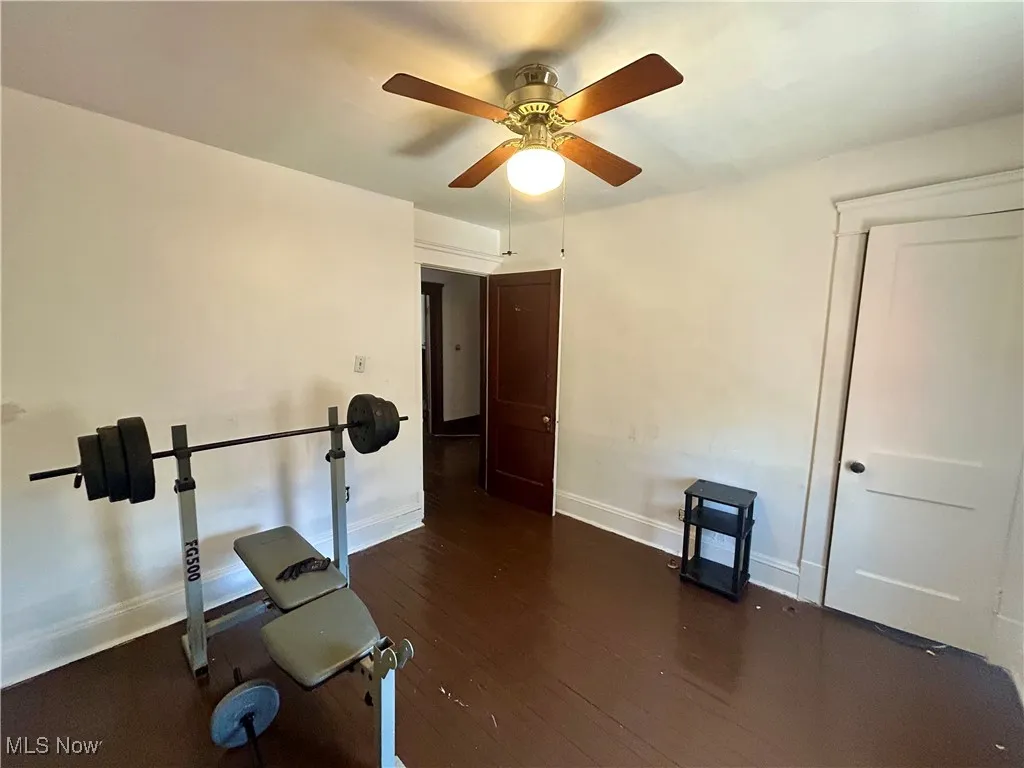 Workout area featuring baseboards, a ceiling fan, and wood finished floors