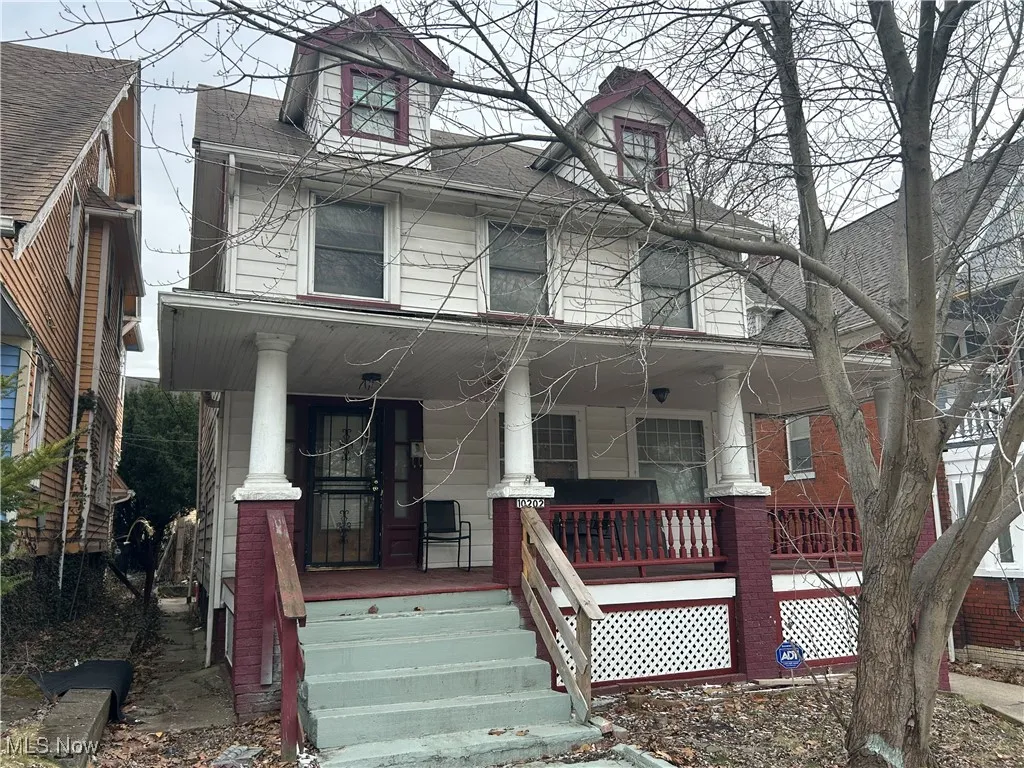 View of property with a porch and roof with shingles