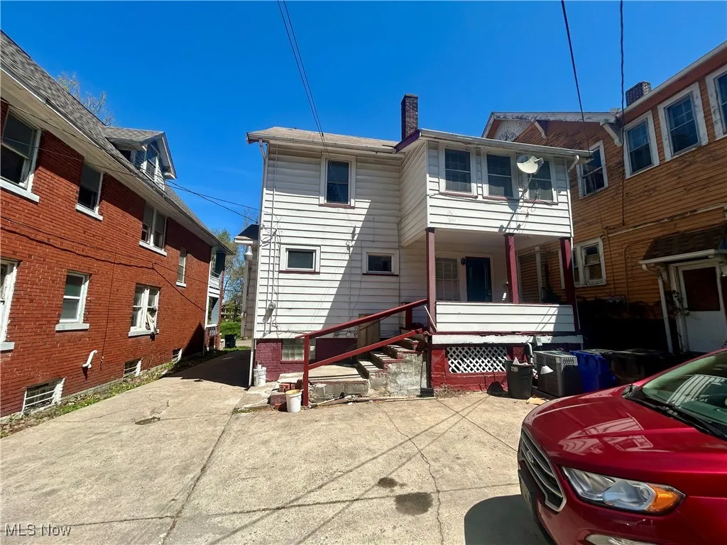 Back of property with a porch and a chimney