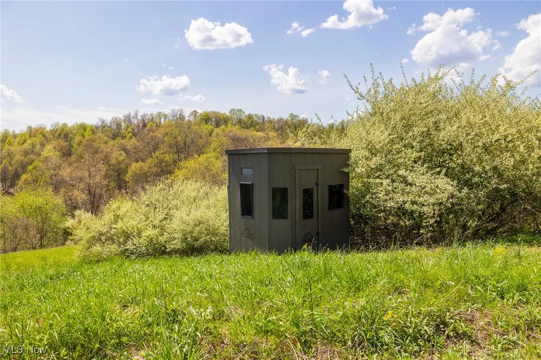 View of outdoor structure featuring an outbuilding and a wooded view