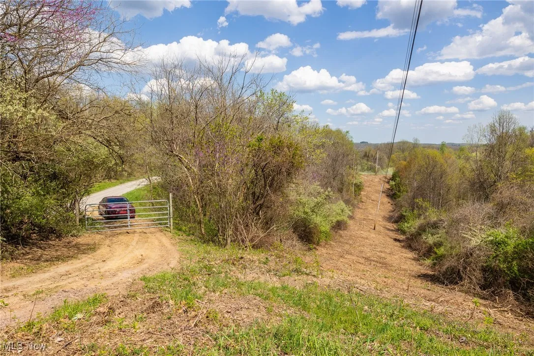 View of road featuring a gate and a rural view
