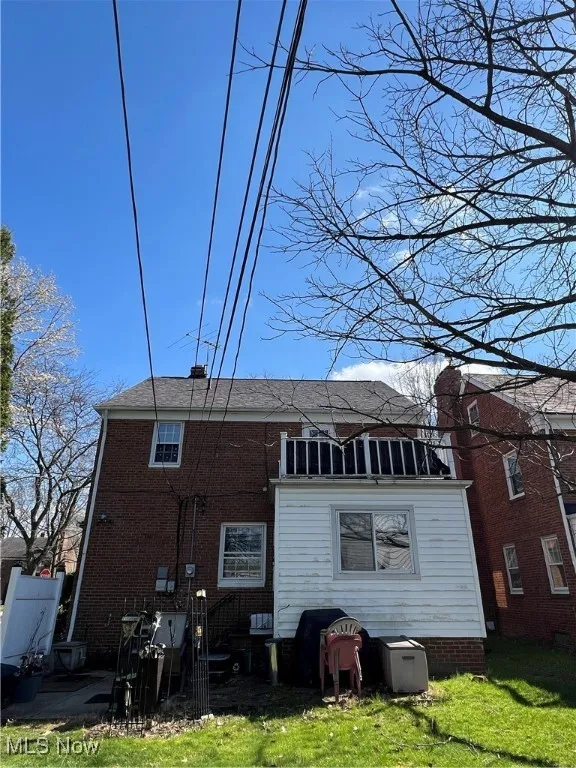 Rear view of property with brick siding