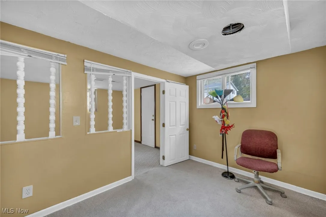 Living area with baseboards and carpet