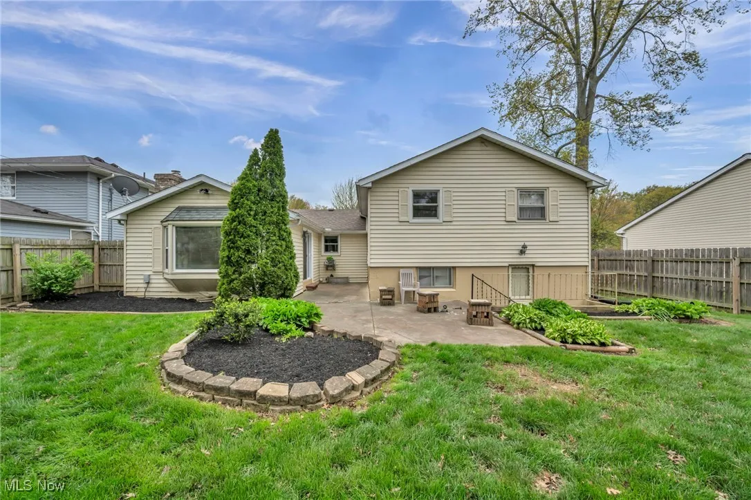 Rear view of property featuring a yard, a patio, and a fenced backyard