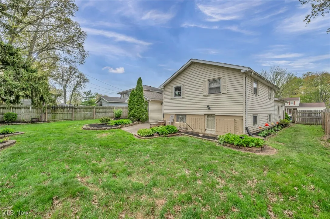 View of home's exterior featuring a lawn, a fenced backyard, and a patio area
