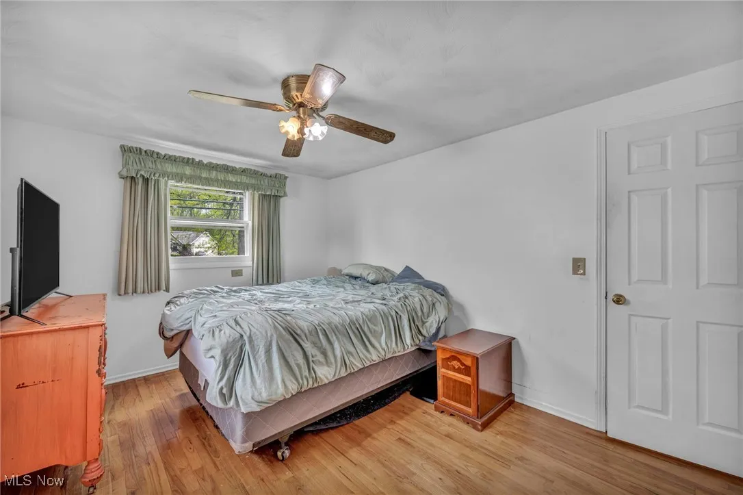 Bedroom with baseboards, a ceiling fan, and light wood-type flooring