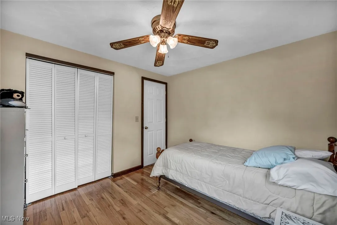 Bedroom featuring baseboards, ceiling fan, a closet, and wood finished floors