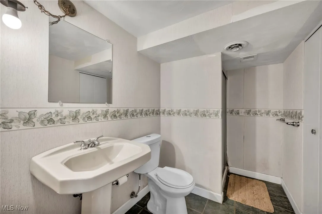 Bathroom featuring visible vents, tile patterned floors, toilet, and a shower stall