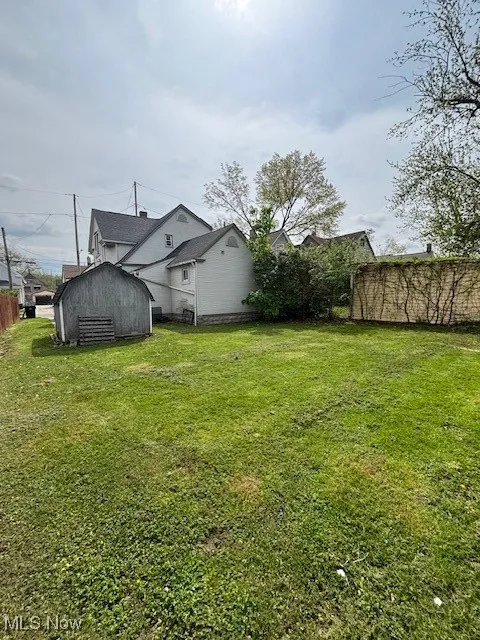 View of yard with fence, an outbuilding, and a shed
