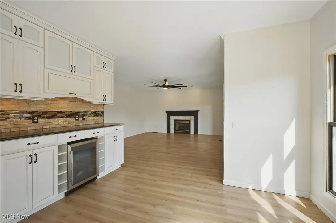 Kitchen featuring dark countertops, backsplash, and light wood-style flooring