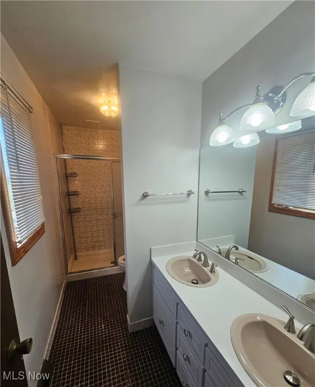 Full master bath with tile patterned flooring, a sink, and a shower stall