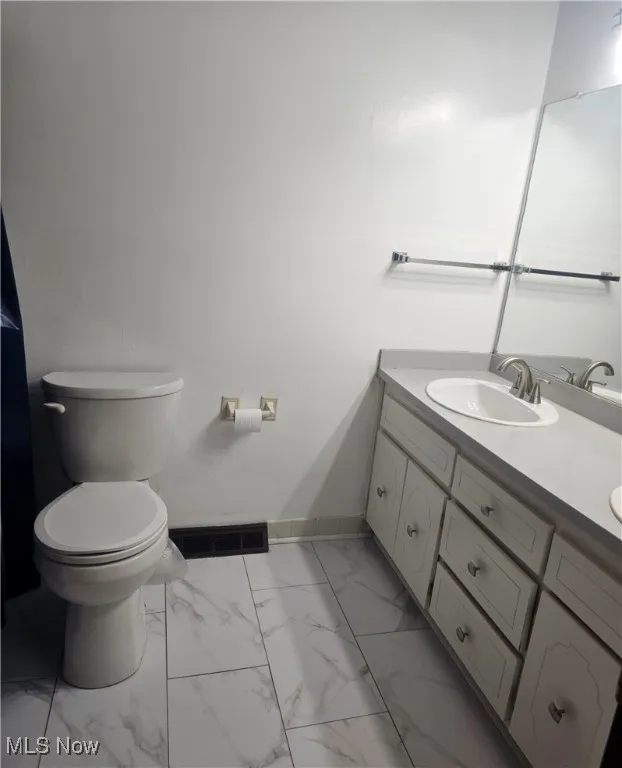 Bathroom with baseboards, vanity, marble finish floor, and visible vents